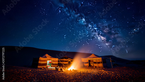 Yurts in desert at night under starry sky with campfire burning brightly outside transparent background
