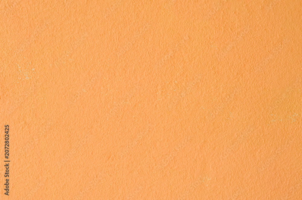 Fototapeta premium Bright orange colored plaster surface for energetic commercial backdrop designs.