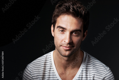 Happy, man and designer in studio with portrait, career pride and about us for fashion. Mockup space, person and entrepreneur with ambition, positive attitude and apparel tailor on dark background