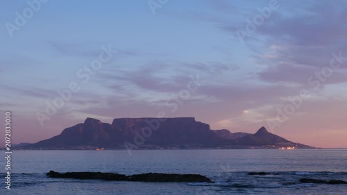 4K 25fps footage from Bloubergstrand showcasing the iconic Cape Town skyline with Table Mountain, Devil’s Peak and Lion’s Head across Table Bay under clear South African blue skies.