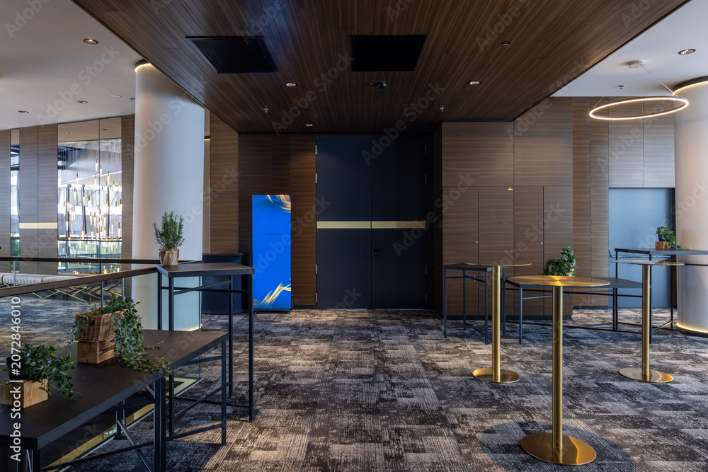 Naklejka premium Modern cocktail lounge interior with gold tables and stylish ring lights