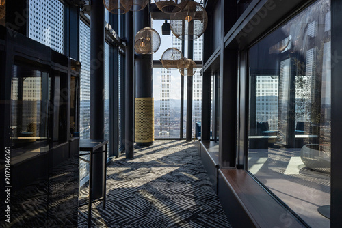Contemporary rooftop bar corridor with large windows and geometric patterned carpet