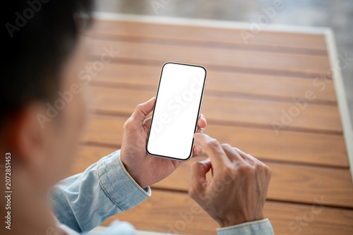 Obraz na płótnie Close up of a man using white screen smartphone over wooden table, suitable for digital marketing