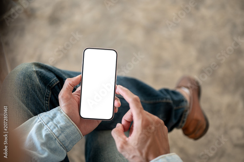 Quadro su tela Overhead close up of blank screen smartphone in a man's hand, perfect for mobile