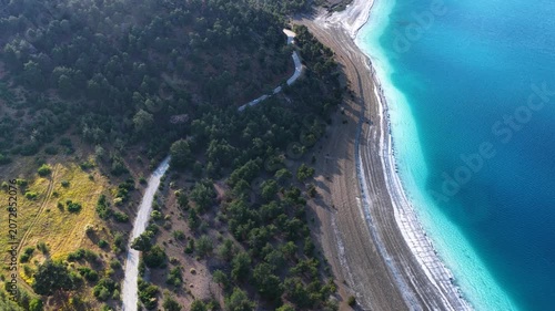 A unique drone view of Lake Salda’s magnificent turquoise waters, winding lakeside road, and lush forest scenery.