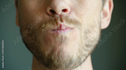 Close up man with beard eating fresh sushi roll with bare hands, putting food in mouth, chewing with appetite. Delicious japanese food concept. Bearded man eating sushi roll with bare hands close up