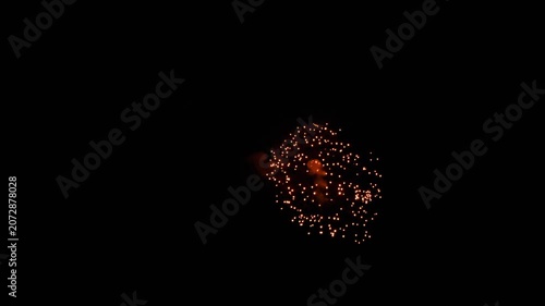 Colorful fireworks exploding and sparkling in the dark night sky during holiday celebration, captured in real time wide shot.