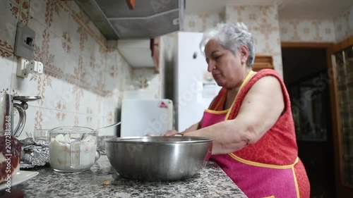  Mujer mayor agregando carne molida y ajo en un tazón para mezclar. Abuela mayor mezclando carne molida y ajo en un tazón. Receta tradicional de albóndigas caseras, auténtica cocina senior.