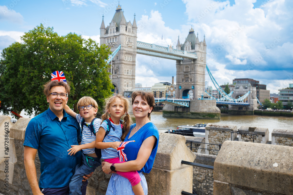 Obraz premium Family of four posing near Tower Bridge on the Thames in London