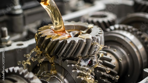 Pouring golden oil onto gears in machinery