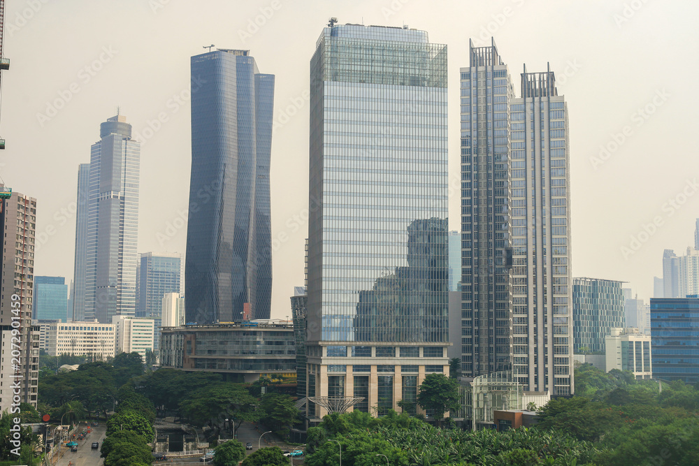 Obraz premium Dense Metropolitan Skyline Features Towering Glass Skyscrapers And Contemporary Highrise Buildings