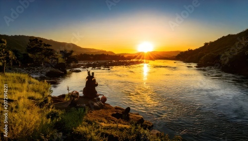 Serene Sunset Over River with Silhouette of People Enjoying the View.