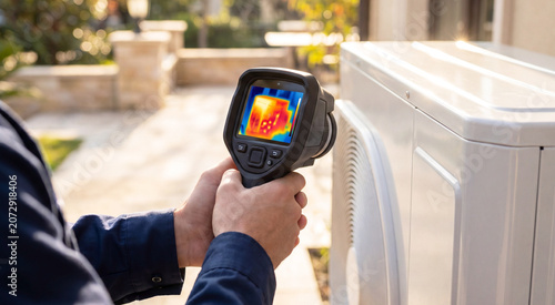 Bild auf Leinwand HVAC Technician Inspecting Outdoor Air Conditioner With Thermal Camera