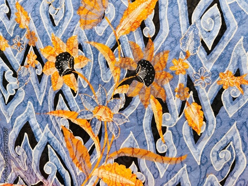 Foto A beautiful Indonesian batik fabric featuring floral, leaf, and cloud motifs from the city of Cirebon, dominated by blue and brown hues