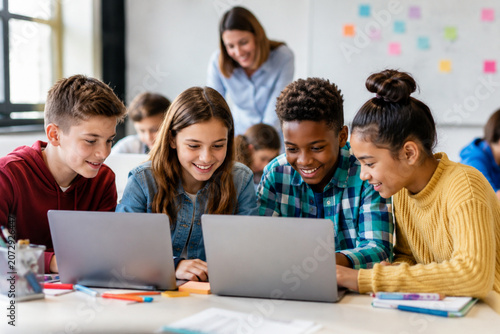 Diverse group of happy students working together on laptops in a modern classroom.