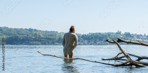 Obraz na plátně Person standing in lake constance water looking at horizon