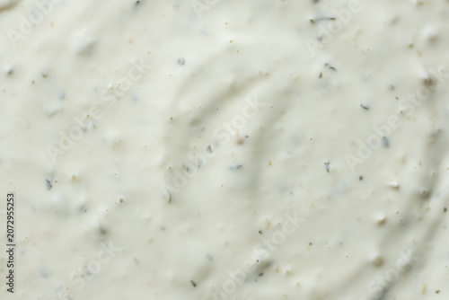 Close-up texture of creamy tartar sauce with herbs top view