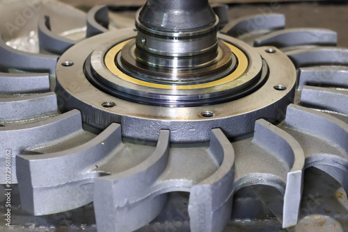 Foto Close up view of a metallic hydraulic retarder rotor with curved impeller blades, brass washer ring, and center shaft assembly for heavy vehicle transmission braking system