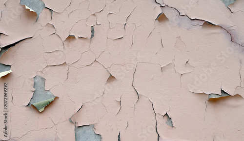 Bild auf Leinwand Close up of a weathered deteriorating tan painted wall surface with cracked peel