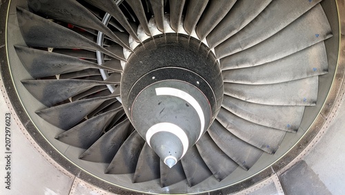 Close-up of an aircraft turbofan engine showing the front fan blades and spinner cone. Industrial aviation background emphasizing engineering, technology, and aerodynamics