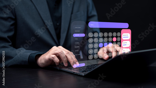 Calendar app, user interface, UI, holographic, scheduling, businessman, laptop and digital concept — a man uses a laptop with a holographic purple calendar app floating above it.