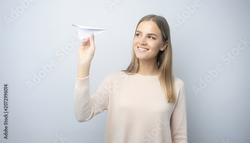 Woman in white sleeveless pointing upwards with a smile