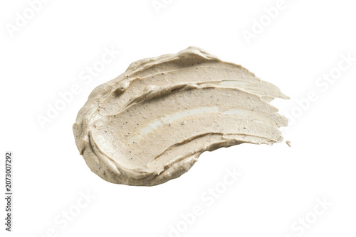 A thick smear of beige exfoliating facial scrub with visible particles, isolated on a white background, showing a creamy and textured consistency
