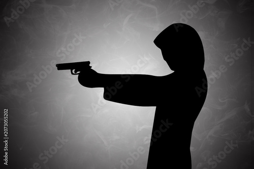 Mysterious dark silhouette of a hooded figure holding a handgun, presented against a moody, smoky background