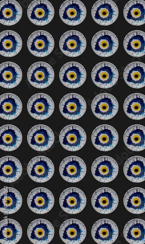 Creative pattern made of colorful blue and yellow evil eye on black background. Creative modern vertical design.