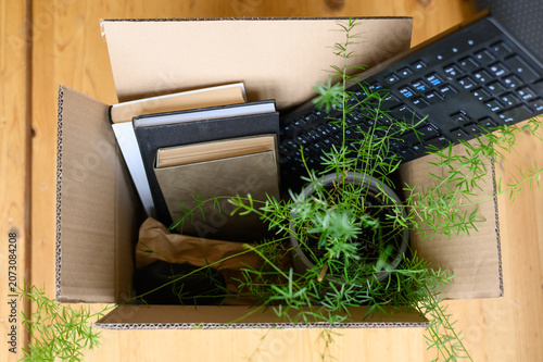 Cardboard box filled with office items leaving employment