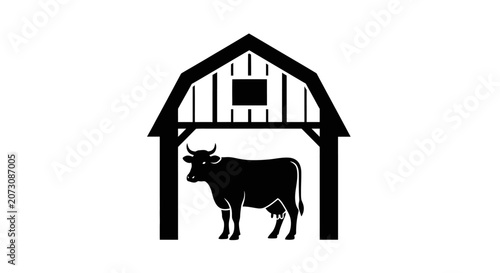 Cow stands inside a wooden barn structure providing shelter for livestock on a farm.