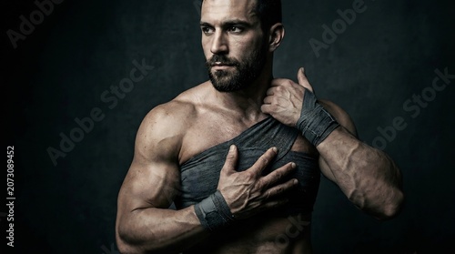 筋肉質な男性が肩に包帯を巻いているポートレート写真