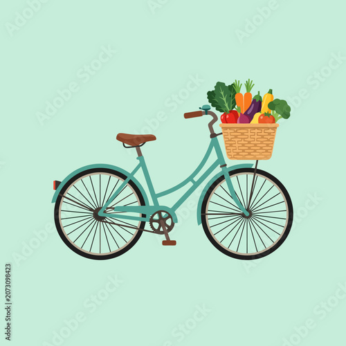 A teal vintage bicycle carries a basket full of fresh vegetables