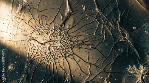 Extreme macro texture of cracked gelatin emulsion on damaged analog film showing severe reticulation
