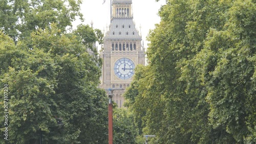 Big Ben tower visible between lush green trees.