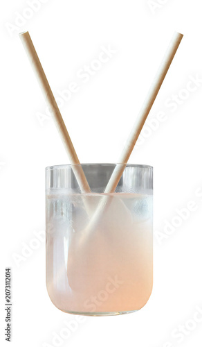 Refreshing pink iced lemonade in a glass with condensation and eco-friendly paper straws