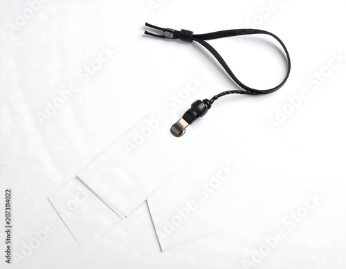 A black cord with a connector lies beside three transparent plastic pieces on a white surface