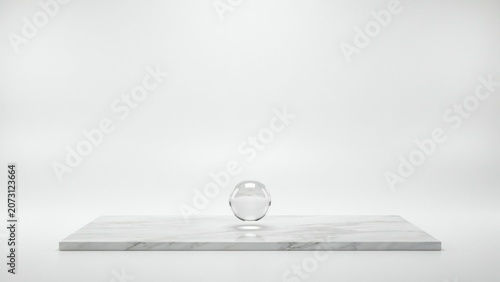 Clear glass sphere floating above a white marble rectangular platform