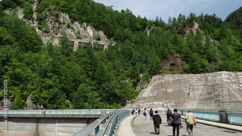 初夏の観光名所立山黒部アルペンルートの黒部ダムで散策している人々の観光客の姿