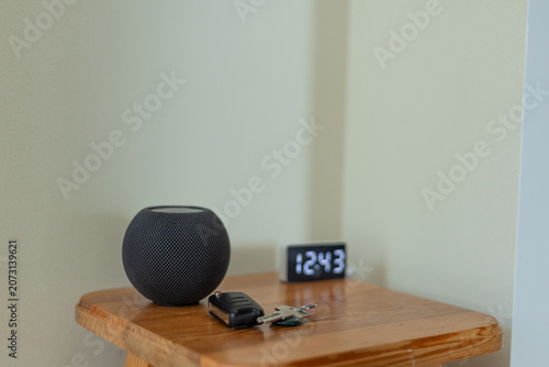 Modern home decor featuring a smart speaker and clock on wooden table