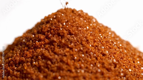 Close up of brown sugar granules pouring into pile