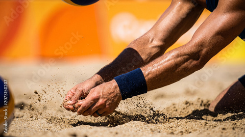 Beach volleyball player bumping the ball in the sand during a sunny game