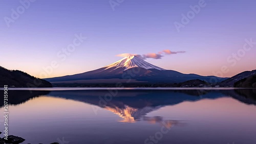 Mount Fuji peak reflected in still lake at sunrise