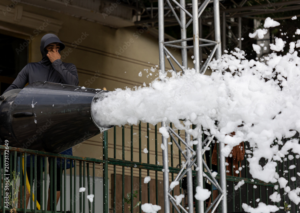 Fototapeta premium Man operates snow cannon at event