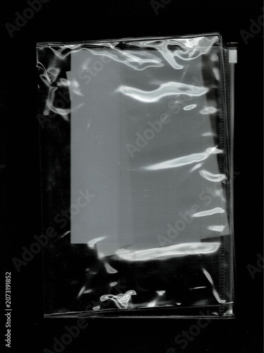 Clear plastic document bag with blank paper on black background