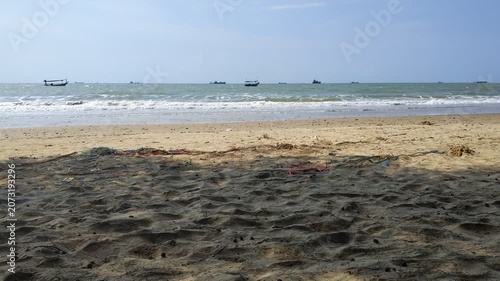 Scenic view of a tropical sand beach with rolling sea waves under a clear blue sky