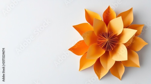 A flat lay image of an orange paper flower on a white background offering ample copy space