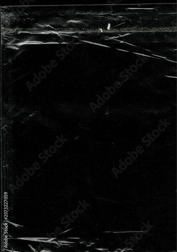Transparent crumpled plastic wrap texture on black background