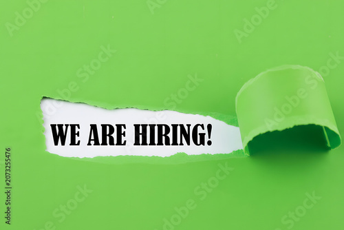 We Are Hiring Message Revealed Through Torn Lime Green Paper For Recruitment Career Opportunity And Human Resources Concept