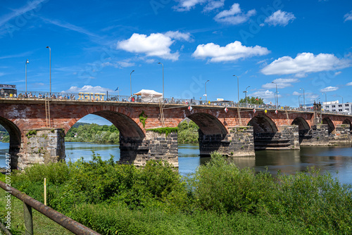 Vor mir spannte sich die alte Steinbrücke über das Wasser, Die Mosel glitzerte in der Sommersonne, Wolken segelten über den Himmel wie langsam ziehende Schiffe, und auf der Brücke mischten sich Reisen